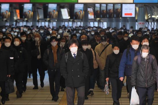 1月8日，在日本東京品川站，人們戴口罩出行。新華社 圖